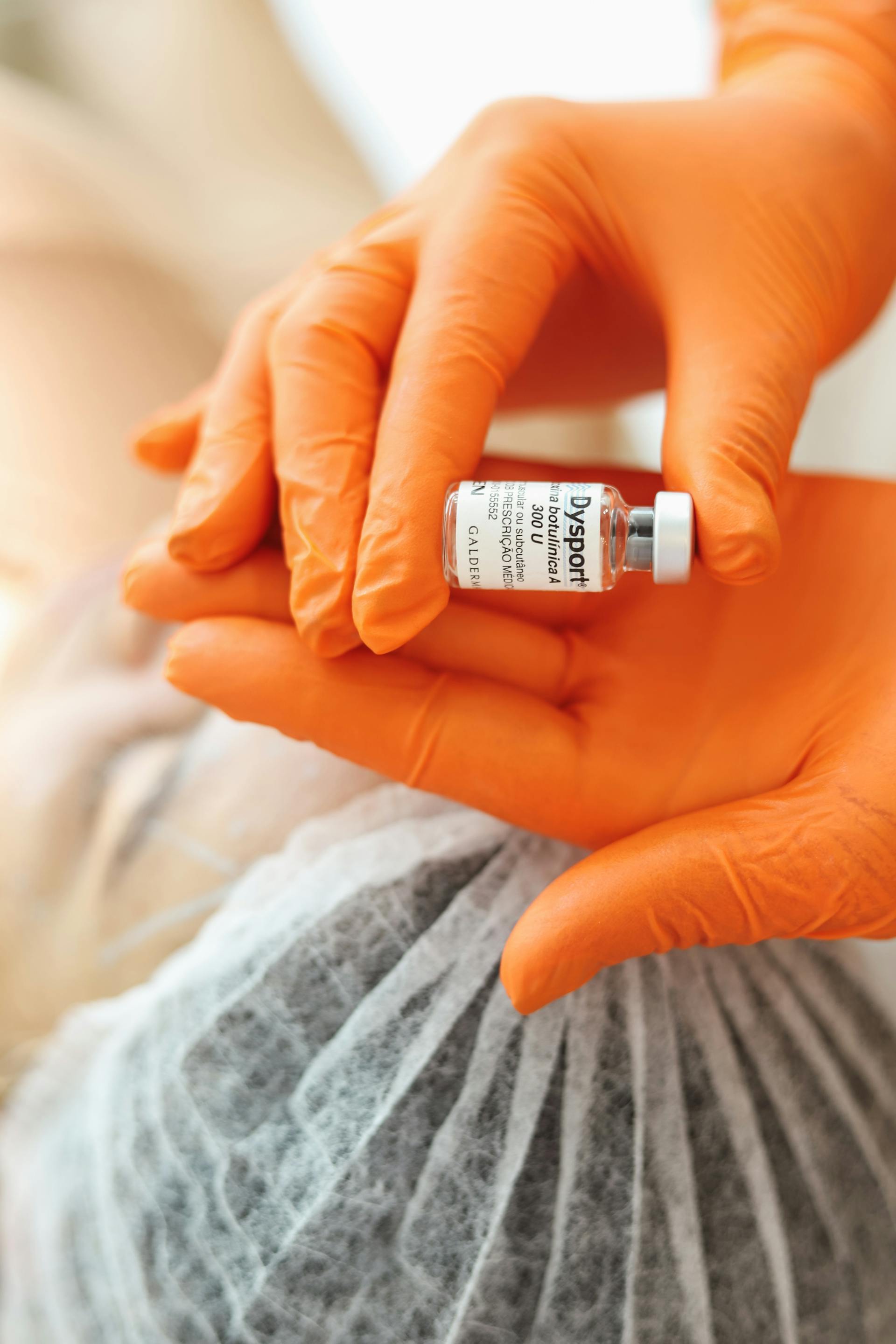 Minimalistic image featuring two syringes labeled 'Botox' and 'Dysport' with a pastel blue and green background, symbolizing a comparison of wrinkle treatments.
